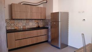 a kitchen with wooden cabinets and a stainless steel refrigerator at Appartamento Trezzo sull'Adda in Trezzo sullʼAdda