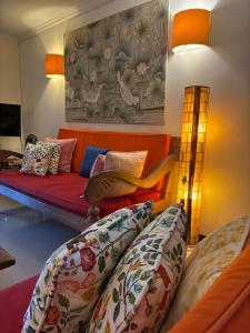 a living room with an orange couch and pillows at Villa Kunang in Seminyak