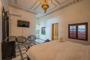a bedroom with a large bed and a chandelier at Riad Old City Palace in Fez