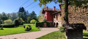 a red house with a stone wall and a yard at Gaztañeta Baserria in Olaeta
