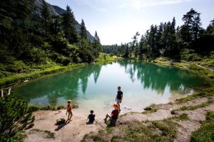 a man and three children standing next to a river at NOOK - Nature Hideaway in Bad Aussee +5 photos