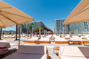 a beach with chairs and umbrellas and some buildings at Studio Matias 2 Casa Del Mar in Mamaia
