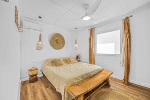 a white bedroom with a bed and a window at Ô Bel Appart, piscine privée & BBQ, ambiance balinaise in Les Cocos