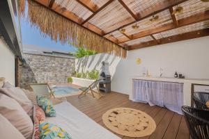 a living room with a couch and a table at Ô Bel Appart, piscine privée & BBQ, ambiance balinaise in Les Cocos