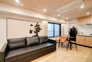 a living room with a black leather couch and a table at YCYC Hotel in Tokyo