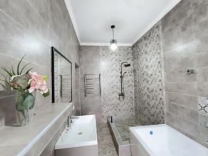 a bathroom with a sink and a tub and a vase of flowers at Meridian Hostel in Almaty +17 photos