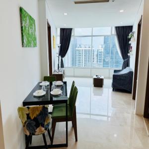 a dining room with a table and chairs and a living room at Vortex by klcc view in Kuala Lumpur