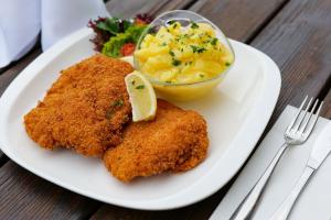 a white plate with fried chicken and a bowl of macaroni and cheese at Waldschlössl Gasthof in Sankt Lorenzen ob Murau