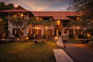 a man and a woman walking in front of a house at Palin Family Cottage in Chiang Rai
