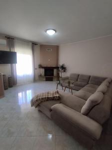 a large living room with a couch and a fireplace at Karina in Carini