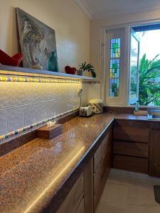 a kitchen with a counter with a sink and a window at Villa Kunang in Seminyak