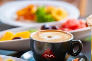 a cup of coffee on a table with a plate of food at Waldschlössl Gasthof in Sankt Lorenzen ob Murau