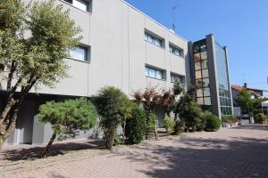 a white building with trees in front of it at Green Hotel in Poviglio