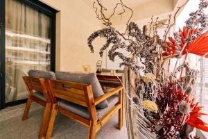 a wooden bench in a room with a table and flowers at Studio Matias 2 Casa Del Mar in Mamaia
