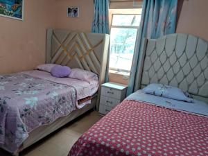 a bedroom with two beds and a window at Hospedaje Don Pepe in Churín