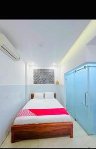 a bedroom with a bed with a red blanket at Tây Nguyên hotel Đà Nẵng in Danang