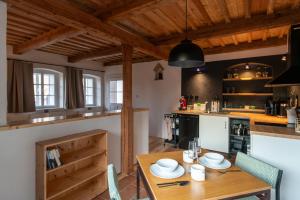 a kitchen with a wooden table and some chairs at Königův mlýn in Úštěk