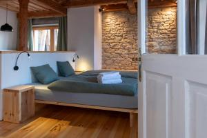 a bedroom with a bed and a stone wall at Königův mlýn in Úštěk