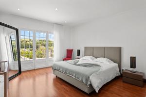 a white bedroom with a bed and a window at Quinta da Lu - Azorean Villa in Ribeira Grande +11 photos