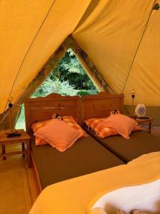 a bedroom with two beds in a tent at Tiszaglamping, the belgian hideaway in Tiszacsege