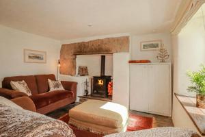 a living room with a couch and a stove at Poldue House in Camelford