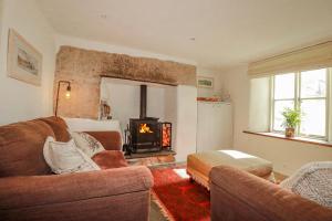 a living room with a couch and a fireplace at Poldue House in Camelford
