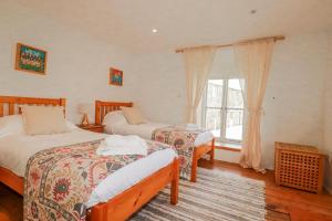 a bedroom with two beds and a window at Poldue House in Camelford