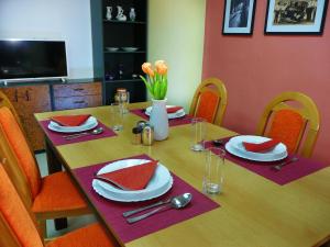 a wooden table with plates and napkins on it at Prízemný apartmán Anika s veľkým parkovaním in Nitra