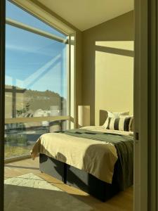 a bedroom with a bed and a large window at Modern and stylish home in Bergen