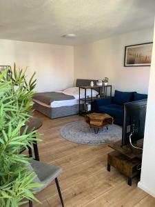 a living room with a bed and a couch at Ruhiges Wohnen nahe Berlin mit schneller S-Bahnanbindung -WLAN und Parkplatz in Bernau bei Berlin