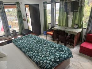 a bedroom with a bed and a table and chairs at The Explorer's Den in Munsyari