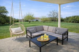 a couch and chairs on a patio with a swing at GUESTHOUSE Kastel Novi 2 More Space in Kaštela