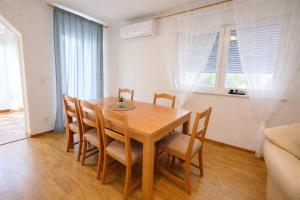 a dining room with a wooden table and chairs at GUESTHOUSE Kastel Novi 2 More Space in Kaštela