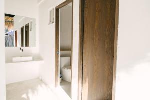 a bathroom with a toilet and a mirror at Villa Gumamela Siargao in Catangnan +37 photos