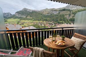 a table with two glasses of wine on a balcony at Lodge Montëva - Le Chinaillon - Au pied des pistes in Le Grand-Bornand