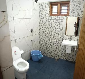 a bathroom with a toilet and a sink at Sandora Home Stay in Varkala +14 photos