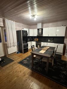 a kitchen with a table and a kitchen with white cabinets at Pihlamäe holiday house in Aruvalla