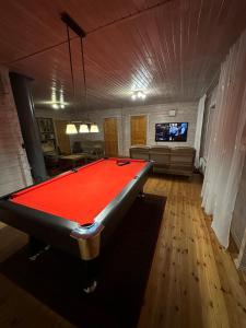 a pool table in the middle of a living room at Pihlamäe holiday house in Aruvalla