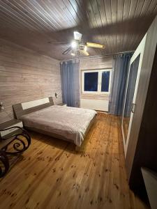 a bedroom with a bed and a ceiling fan at Pihlamäe holiday house in Aruvalla