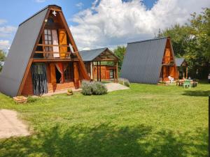 a home with two story houses on a grass field at Cabañas Don Luis in Valle Hermoso