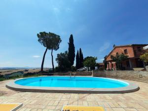 a large blue swimming pool in a yard with a house at Alloggi degli Artisti in Case Selva Grande