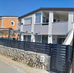 a house with a fence and a stone wall at Kele Apartment in Vir