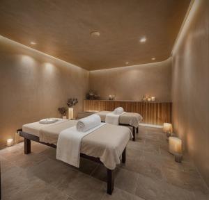 a room with three beds with towels on them at Venus Beach Hotel in Paphos