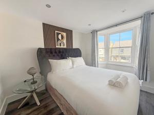 a bedroom with a large white bed with a window at Bletchley Retreat in Bletchley