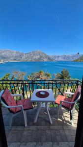 a table and chairs on a patio with a view of the water at Apartment Capt Seferovic 2 in Donji Morinj