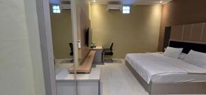 a bedroom with a bed and a desk in it at Hotel Tian in Nabire