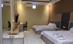 a hotel room with two beds and a television at Hotel Tian in Nabire