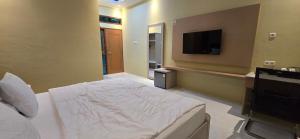 a bedroom with a bed and a flat screen tv at Hotel Tian in Nabire