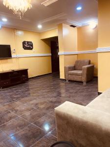 a waiting room with a chair and a flat screen tv at Executive 2BR at Redemption Camp in Loburo +19 photos