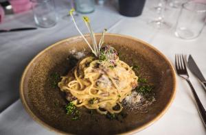 a bowl of pasta with vegetables on a table at Hotel Victoria Lauberhorn Wengen, a Faern Collection Hotel in Wengen
